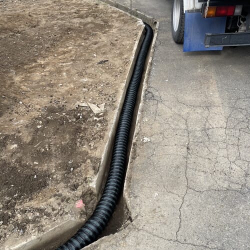 側溝への排水ドレイン管の敷設作業となります。