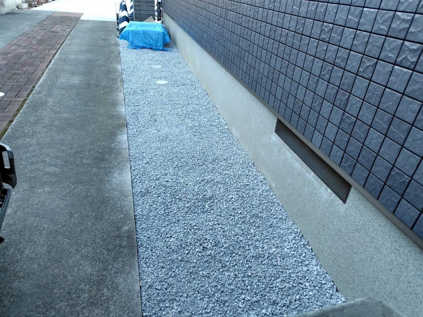 防草シートを敷いた後の建物廻りへの6号砕石の敷き込み作業となります。