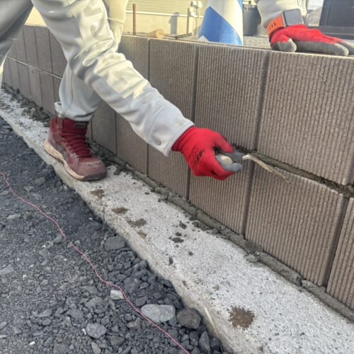 東側の境界ブロック積み作業となります。ブロックを積んで目地を切って1段また1段と積んで参ります。