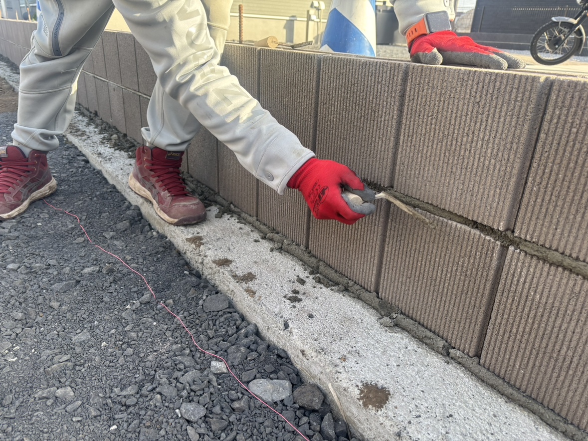 東側の境界ブロック積み作業となります。ブロックを積んで目地を切って1段また1段と積んで参ります。