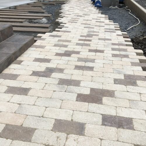 アプローチのインターロッキングへの珪砂入れ作業となります。