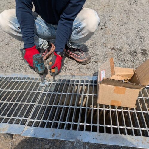 出入り口側溝へのグレーチングの設置作業となります。
