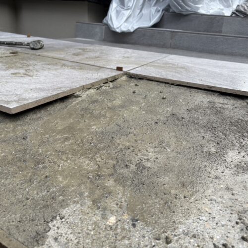 玄関前のアプローチのタイル張り作業となります。