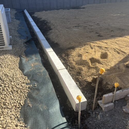 お庭側の見切りのコンクリートの縁石を敷設して参ります。お庭は来年の春に芝張り予定です。