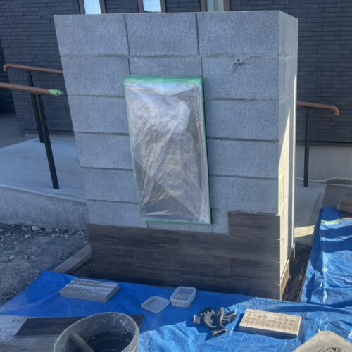 門袖部分のタイル張り作業開始です。寒い中のタイル張り作業は使用するボンドを温めててタイル張りを進めます。