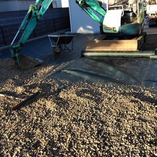 お庭への防草シート敷き後の茶色の砕石チャートの敷き込み作業となります。