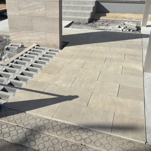 アプローチの300×600寸法の平板敷き作業完了です。玄関から側溝までの寸法が決まってしまい側溝取り合いに今回は細物を入れて敷き入れました。