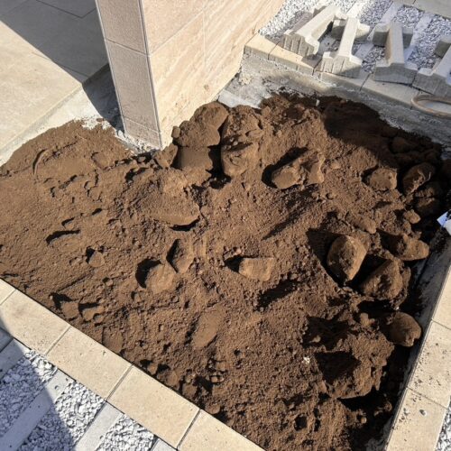 花壇部分への黒土入れの作業となります。