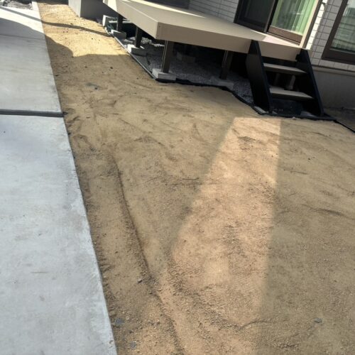 ウッドデッキ廻りの人工芝下地の為の山砂を搬入しまして転圧の作業中となります。