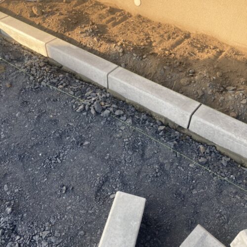 人工芝と砂利敷きの間に施工する見切り材のコンクリート縁石の施工です。