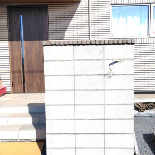 塗り壁の門袖ブロックに笠木の取り付け作業となります。