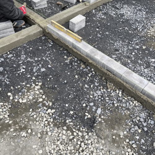 カーポート駐車場部分へのインターロッキングの見切りの敷設作業となります。