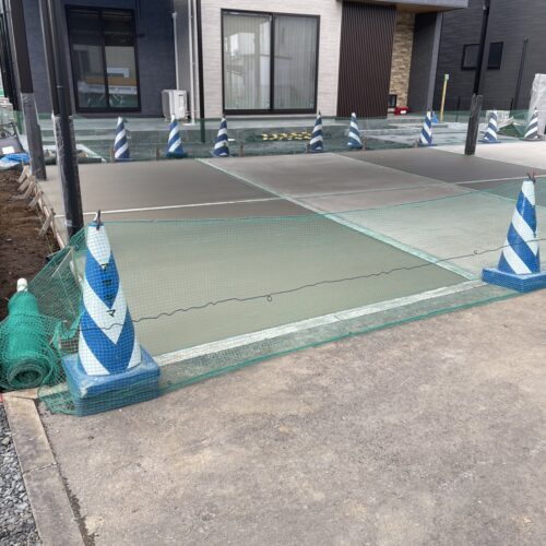 駐車場部分のコンクリート打設後に動物避けネットを張って養生中となります。