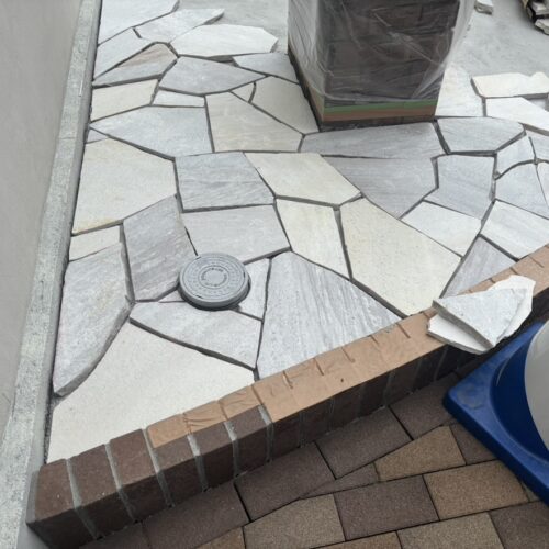 玄関アプローチ横の自然石の乱張り作業となります